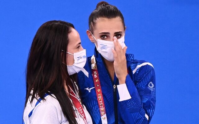 Israel's Linoy Ashram (C) celebrates with her coach winning the individual all-around final of the Rhythmic Gymnastics event during Tokyo 2020 Olympic Games at Ariake Gymnastics centre in Tokyo, on August 7, 2021. (Martin BUREAU / AFP)