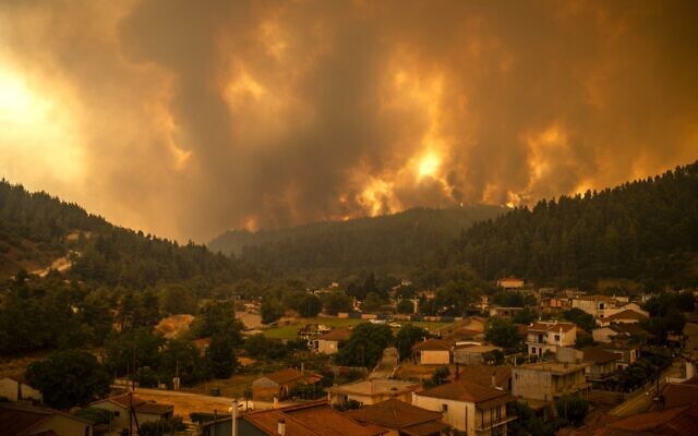 This picture taken on Evia island, the second largest Greek island, on August 8, 2021 shows a wildfire moving towards the village of Gouves. (Photo by ANGELOS TZORTZINIS / AFP) This picture taken on Evia island, the second largest Greek island, on August 8, 2021 shows a wildfire moving towards the village of Gouves. (Photo by ANGELOS TZORTZINIS / AFP)