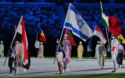 Israeli gold medalist Linoy Ashram (C) carries the national flag during the closing ceremony of the Tokyo 2020 Olympic Games, at the Olympic Stadium, in Tokyo, on August 8, 2021. (Adek BERRY / AFP)