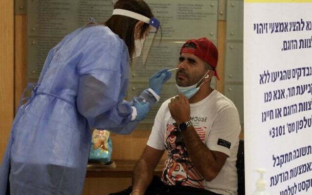 A paramedic with Israel's Magen David Adom medical service performs a rapid COVID-19 antigenic test in Jerusalem on August 8, 2021. (MENAHEM KAHANA / AFP) A paramedic with Israel's Magen David Adom medical service performs a rapid COVID-19 antigenic test in Jerusalem on August 8, 2021. (MENAHEM KAHANA / AFP)