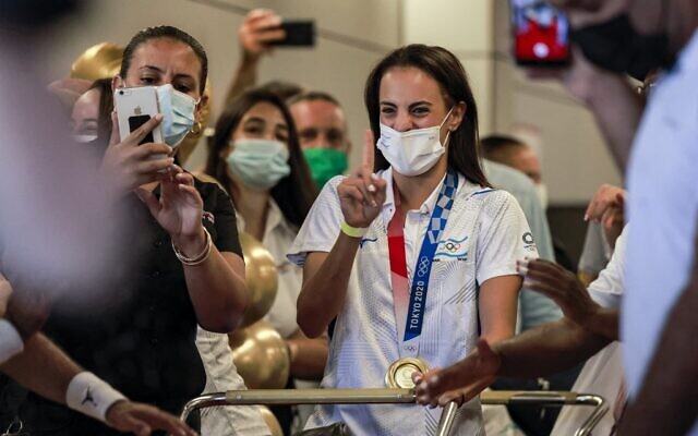Olympic Gold medalist Linoy Ashram is greeted by press, family and friends as she arrives at Ben Gurion Airport after winning the Gold medal in the rhythmic gymnast at the Olympic Games in Japan, August 11, 2021. (Menahem KAHANA / AFP) Olympic Gold medalist Linoy Ashram is greeted by press, family and friends as she arrives at Ben Gurion Airport after winning the Gold medal in the rhythmic gymnast at the Olympic Games in Japan, August 11, 2021. (Menahem KAHANA / AFP)