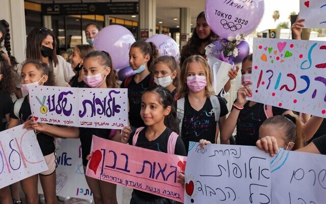 Supporters of Rhythmic Gymnastics gold medalist Linoy Ashram wait for her outside at Ben Gurion Airport on August 11, 2021 upon her arrival from Tokyo. (Menahem KAHANA /AFP) Supporters of Rhythmic Gymnastics gold medalist Linoy Ashram wait for her outside at Ben Gurion Airport on August 11, 2021 upon her arrival from Tokyo. (Menahem KAHANA /AFP)