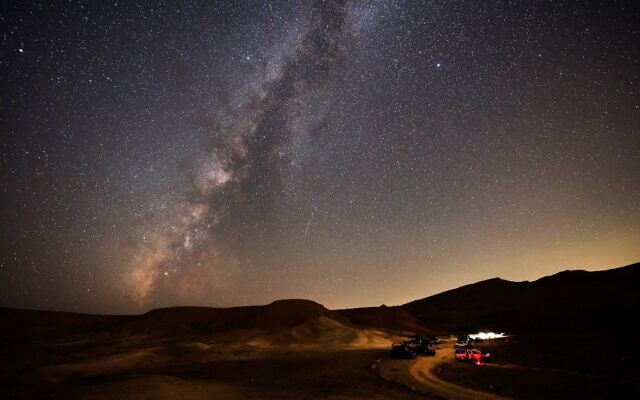 File - The Milky Way galaxy is pictured as a Perseid meteor streaks across the sky above the Negev desert near the southern town of Mitzpe Ramon, August 13, 2021. (Menahem Kahana/AFP)