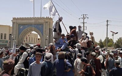 Taliban fighters stand on a vehicle along the roadside in Kandahar on August 13, 2021. (AFP)