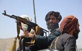 Taliban fighters stand guard in a vehicle along the roadside in Kabul on August 16, 2021 (AFP)
