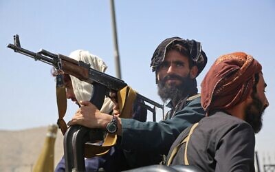 Taliban fighters stand guard in a vehicle along the roadside in Kabul on August 16, 2021 (AFP)
