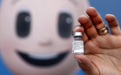 A medic holds up a vial of the Pfizer-BioNTech COVID-19 coronavirus vaccine at a vaccination centre at the Atid al-Najah High School for the Sciences at the city of Taibeh in northern Israel on August 19, 2021. (JACK GUEZ / AFP)