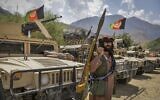 An armed Afghan man supporting the Afghan security forces against the Taliban stands next to humvees at Parakh area in Bazarak, Panjshir province, on August 19, 2021. (Ahmad Sahel Arman/AFP)
