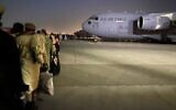 Afghans line up to board a US military aircraft to leave Afghanistan, at the military airport in Kabul, on August 19, 2021, after the Taliban's takeover of Afghanistan. (Shakib Rahmani/AFP)