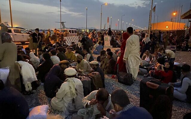 Afghan people wait to board a U S military aircraft to leave Afghanistan, at the military airport in Kabul on August 19, 2021 after Taliban's military takeover of Afghanistan. (Shakib RAHMANI / AFP) Afghan people wait to board a U S military aircraft to leave Afghanistan, at the military airport in Kabul on August 19, 2021 after Taliban's military takeover of Afghanistan. (Shakib RAHMANI / AFP)