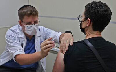 A health worker administers a third dose of the Pfizer-BioNtech COVID-19 vaccine at a Maccabi Health Services clinic in Jerusalem, on August 20, 2021, soon after Israel approved booster shots for people over 40 - a decision that was later expanded to. the entire population. (Ahmad Gharabli/AFP) A health worker administers a third dose of the Pfizer-BioNtech COVID-19 vaccine at a Maccabi Health Services clinic in Jerusalem, on August 20, 2021, soon after Israel approved booster shots for people over 40 - a decision that was later expanded to. the entire population. (Ahmad Gharabli/AFP)
