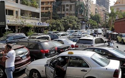 Lebanese wait in a line outside a closed petrol station in Beirut's Hamra district  on August 20, 2021.(Photo by ANWAR AMRO / AFP)