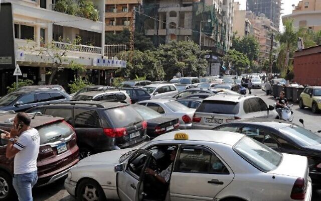 Lebanese wait in a line outside a closed petrol station in Beirut's Hamra district  on August 20, 2021.(Photo by ANWAR AMRO / AFP)