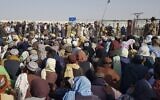 Afghan and Pakistani nationals gather to cross into Afghanistan at the Pakistan-Afghanistan border crossing point in Chaman on August 21, 2021 days after the Taliban stunning takeover of Afghanistan. (Photo by STRINGER / AFP)