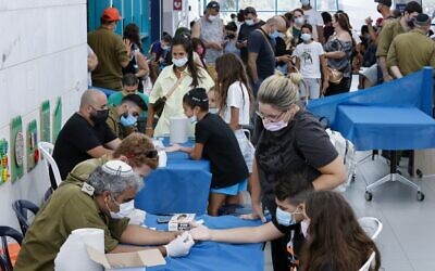 Israeli children undergo COVID-19 antibody testing in the coastal city of Netanya on August 22, 2021. (JACK GUEZ / AFP)