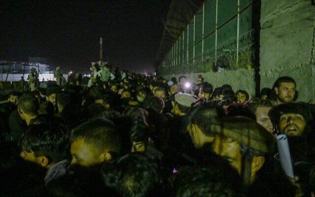 In this picture taken in the late hours on August 22, 2021 Afghans wait outside the foreign military-controlled part of the airport in Kabul, hoping to flee the country following the Taliban's military takeover of Afghanistan. (WAKIL KOHSAR / AFP)