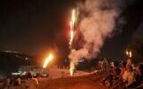 In this file photo taken on August 3, 2021, Palestinians light up flares as they gather for a demonstration against the Israeli outpost of Evyatar in the village of Beita in the West Bank. (JAAFAR ASHTIYEH / AFP)