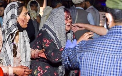 Wounded women arrive at a hospital for treatment after two deadly blasts outside the airport in Kabul on August 26, 2021. (Wakil KOHSAR / AFP)