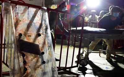 EDITORS NOTE: Graphic content / Medical staff move a stretcher to bring injured people for treatment after two powerful explosions outside the airport in Kabul on August 26, 2021. (Wakil KOHSAR / AFP)