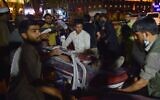 Volunteers and medical staff bring an injured man on a stretcher for treatment after two powerful explosions, which killed at least six people, outside the airport in Kabul on August 26, 2021. (Wakil KOHSAR / AFP)