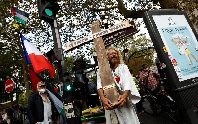 A Frenchman dressed as Jesus holds a cross and a sign reading 'Vaccine = lethal poison' during a rally against the compulsory COVID-19 vaccination for certain workers and the mandatory use of the health pass, near Place du Colonel Fabien in Paris, on August 28, 2021. (Sameer Al-Doumy/AFP) A Frenchman dressed as Jesus holds a cross and a sign reading 'Vaccine = lethal poison' during a rally against the compulsory COVID-19 vaccination for certain workers and the mandatory use of the health pass, near Place du Colonel Fabien in Paris, on August 28, 2021. (Sameer Al-Doumy/AFP)