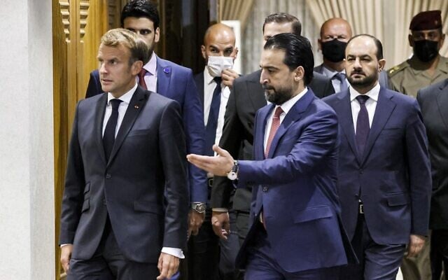 Iraqi Parliament Speaker Muhammad al-Halbousi (R) receives France's President Emmanuel Macron ahead of a meeting at the parliament in the capital Baghdad, on August 28, 2021. (Ludovic MARIN / AFP)