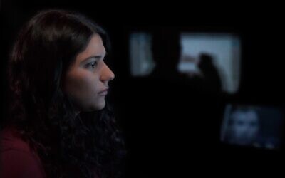 Maia Levy watches footage from the Israeli-Palestinian conflict in the documentary 'The Viewing Booth.' (Courtesy of Atzmor Productions/ via JTA)