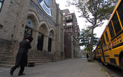 A man walks past an Orthodox yeshiva in Brooklyn, Sept. 29, 2020. (Daniel Moritz-Rabson/ via JTA)