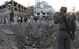 Illustrative: Afghan security forces stand next to a crater created by a massive explosion that killed over 150, according to the Afghan president, in front of the German Embassy in Kabul, Afghanistan, on May 31, 2017. The Taliban's second in command and head of the Haqqani denied Afghanistan's accusation that it was behind the bombing. (AP Photo/Rahmat Gul, File)