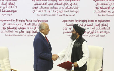 US peace envoy Zalmay Khalilzad, left, and Mullah Abdul Ghani Baradar, the Taliban group's top political leader, shake hands after signing a peace agreement between Taliban and US officials in Doha, Qatar, Saturday, Feb. 29, 2020. (AP Photo/Hussein Sayed)