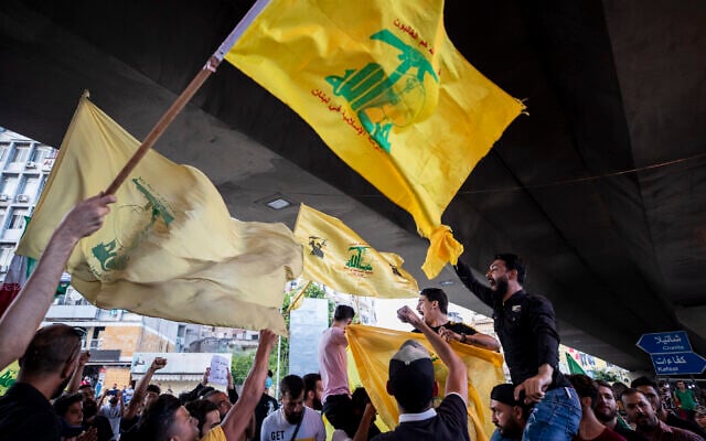 Illustrative: Hezbollah and Amal supporters wave Hezbollah and Iranian flags as they shout slogans against Israel and the US during a protest in the southern suburb of Beirut, Lebanon, June 28, 2020. (AP Photo/Hassan Ammar) Illustrative: Hezbollah and Amal supporters wave Hezbollah and Iranian flags as they shout slogans against Israel and the US during a protest in the southern suburb of Beirut, Lebanon, June 28, 2020. (AP Photo/Hassan Ammar)