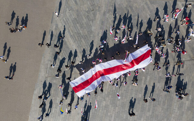 Belarusian activists cast shadows as they carry an old Belarusian flag on a rally in support of Belarus' opposition in the Independence Square in Kyiv, Ukraine, Sunday, Sept. 20, 2020. (AP Photo/Efrem Lukatsky) Belarusian activists cast shadows as they carry an old Belarusian flag on a rally in support of Belarus' opposition in the Independence Square in Kyiv, Ukraine, Sunday, Sept. 20, 2020. (AP Photo/Efrem Lukatsky)