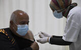 Mohamed Agbariyah receives a coronavirus vaccine at a COVID-19 vaccination center in the northern Arab Israeli town of Umm el-Fahm, January 5, 2021. (AP Photo/Ariel Schalit)