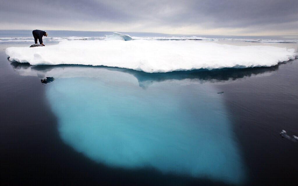 In this file photo dated July 2017, an Inuit seal hunter touches a dead seal atop a melting iceberg near Ammassalik Island, Greenland. (AP Photo/John McConnico, FILE) In this file photo dated July 2017, an Inuit seal hunter touches a dead seal atop a melting iceberg near Ammassalik Island, Greenland. (AP Photo/John McConnico, FILE)