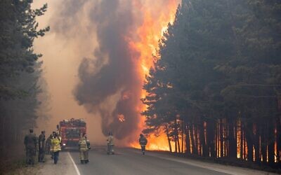 In this June 16, 2021 photo, firefighters work at the scene of a forest fire near Andreyevsky village outside Tyumen, western Siberia, Russia. Wildfires in Siberia are releasing record amounts of greenhouse gases, scientists say, contributing to global warming. Each year, thousands of wildfires engulf wide swathes of Russia, destroying forests and shrouding broad territories in acrid smoke. This summer has seen particularly massive fires in Yakutia in northeastern Siberia following unprecedented heat. (AP Photo/Maksim Slutsky, File)