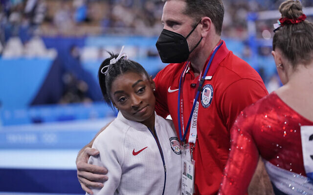Coach Laurent Landi embraces Simone Biles, after she exited the team final, at the 2020 Summer Olympics, July 27, 2021, in Tokyo. (AP/Gregory Bull) Coach Laurent Landi embraces Simone Biles, after she exited the team final, at the 2020 Summer Olympics, July 27, 2021, in Tokyo. (AP/Gregory Bull)