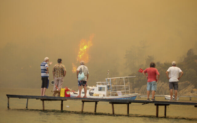 Tourists wait to be evacuated from smoke-engulfed Mazi area as wildfires rolled down the hill toward the seashore, in Bodrum, Mugla, Turkey, Sunday, Aug. 1, 2021. (AP Photo/Emre Tazegul) Tourists wait to be evacuated from smoke-engulfed Mazi area as wildfires rolled down the hill toward the seashore, in Bodrum, Mugla, Turkey, Sunday, Aug. 1, 2021. (AP Photo/Emre Tazegul)