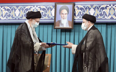 Iran's Supreme Leader Ayatollah Ali Khamenei, left, gives his official seal of approval to newly elected President Ebrahim Raisi in an endorsement ceremony in Tehran, Iran, August 3, 2021. (Office of the Iranian Supreme Leader via AP)