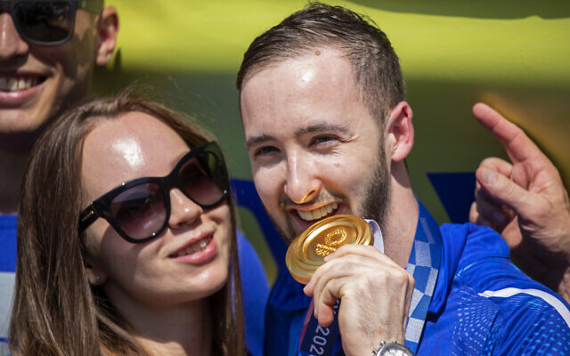 Artem Dolgopyat, Israeli artistic gymnastics men's gold medalist, stands with his fiancée Maria Sakovich, on his arrival at Ben Gurion Airport, August 3, 2021. (AP Photo/Ariel Schalit)
