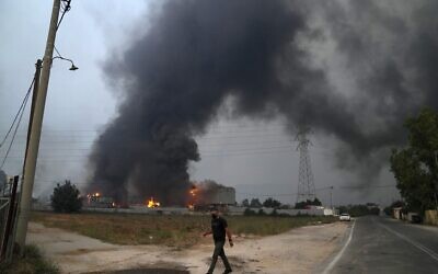 A car recycle plant is on fire during a wildfire in Afidnes village, about 31 kilometres (19 miles) north of Athens, Greece, Friday, Aug. 6, 2021.  (AP Photo/Thanassis Stavrakis)