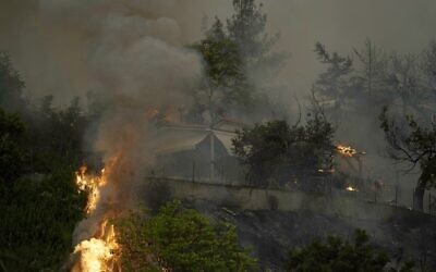 A house is on fire during a wildfire in Afidnes village, about 31 kilometres (19 miles) north of Athens, Greece, Friday, Aug. 6, 2021. (AP Photo/Thanassis Stavrakis)
