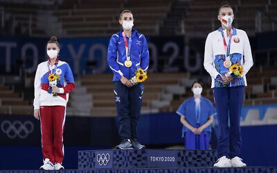 From left, silver medalist Dina Averina, of Russian Olympic Committee, gold medalist Linoy Ashram, of Israel, and bronze medalist Alina Harnasko, of Belarus, stand on the podium after the rhythmic gymnastics individual all-around final at the 2020 Summer Olympics, on August 7, 2021, in Tokyo, Japan. (AP/Ashley Landis)