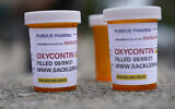 Fake pill bottles with messages about Purdue Pharma are displayed during a protest outside the courthouse where the bankruptcy of the company is taking place in White Plains, New York, August, 9, 2021. (AP Photo/Seth Wenig)
