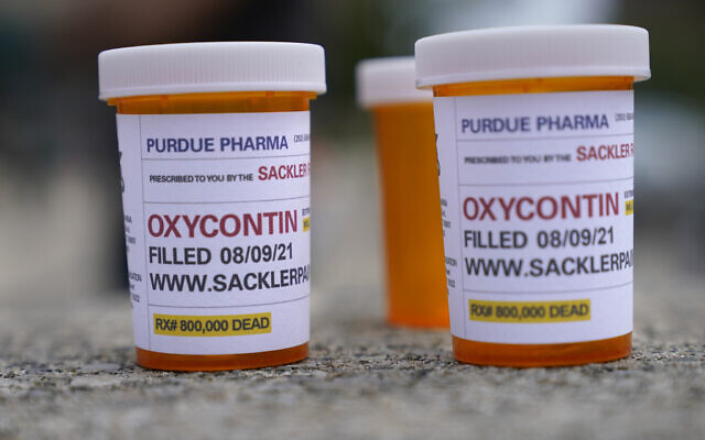 Fake pill bottles with messages about Purdue Pharma are displayed during a protest outside the courthouse where the bankruptcy of the company is taking place in White Plains, New York, August, 9, 2021. (AP Photo/Seth Wenig) Fake pill bottles with messages about Purdue Pharma are displayed during a protest outside the courthouse where the bankruptcy of the company is taking place in White Plains, New York, August, 9, 2021. (AP Photo/Seth Wenig)