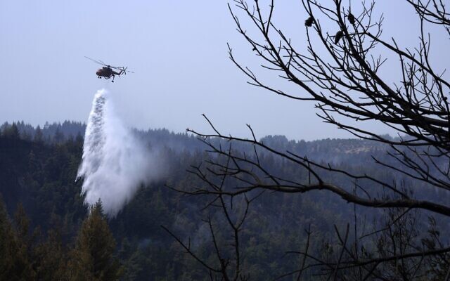 An helicopter drops water over a fire in Avgaria village on Evia island, about 181 kilometers (113 miles) north of Athens, Greece on Aug. 11, 2021. (AP Photo/Petros Karadjias) An helicopter drops water over a fire in Avgaria village on Evia island, about 181 kilometers (113 miles) north of Athens, Greece on Aug. 11, 2021. (AP Photo/Petros Karadjias)