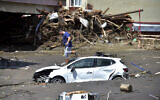 A man checks his car buried in the mud after floods and mudslides killed about three dozens of people, in Bozkurt town of Kastamonu province, Turkey, Friday, Aug. 13, 2021. (AP Photo)