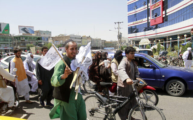 A man sells Taliban flags in Herat province, west of Kabul, Afghanistan, on Aug. 14, 2021. (AP Photo/Hamed Sarfarazi)