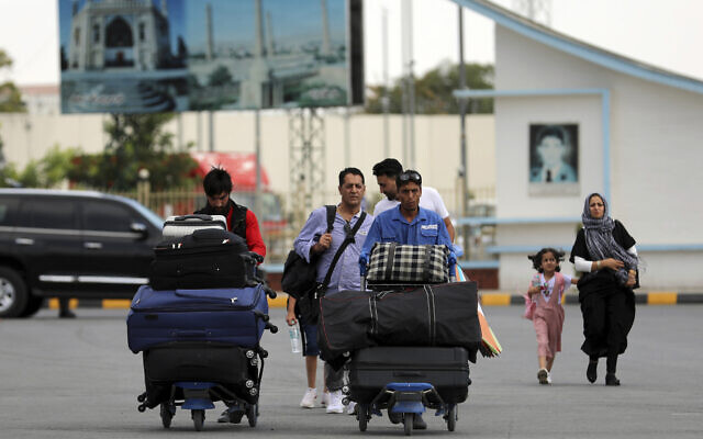 Passengers walk to the departures terminal of Hamid Karzai International Airport in Kabul, Afghanistan, Aug. 14, 2021 (AP Photo/Rahmat Gul)