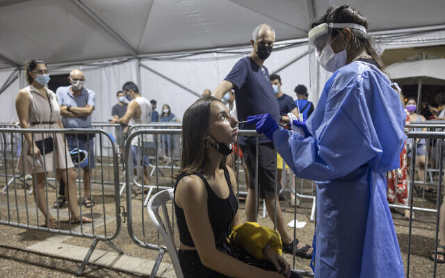 A medical professional takes samples from a woman for a coronavirus test in Rabin Square in Tel Aviv on Aug. 14, 2021. (AP Photo/Tsafrir Abayov) A medical professional takes samples from a woman for a coronavirus test in Rabin Square in Tel Aviv on Aug. 14, 2021. (AP Photo/Tsafrir Abayov)
