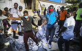 People recover the body of a deceased person from the rubble of a house destroyed by the earthquake in Les Cayes, Haiti, Sunday, Aug. 15, 2021. (AP/Joseph Odelyn)